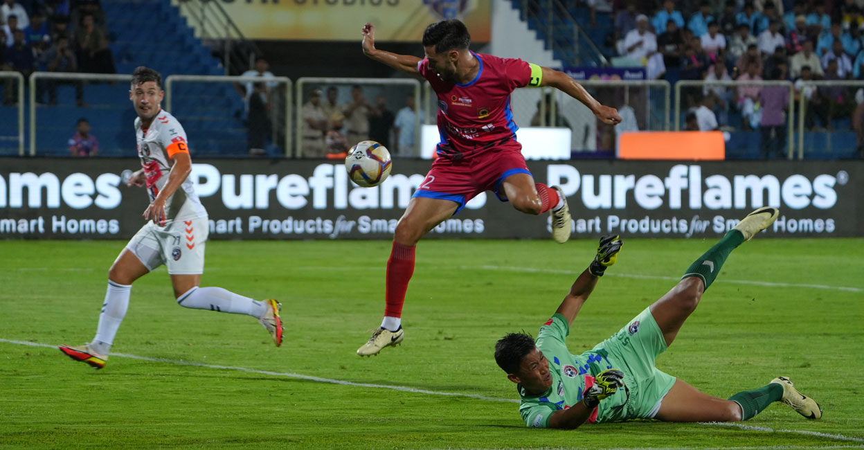mlp-vs-knr-super-league Kannur Warriors' captain Adrian Sardinero Corpa beats Malappuram FC goalkeeper Tenzin Samdup before scoring. Photo: Special arrangement