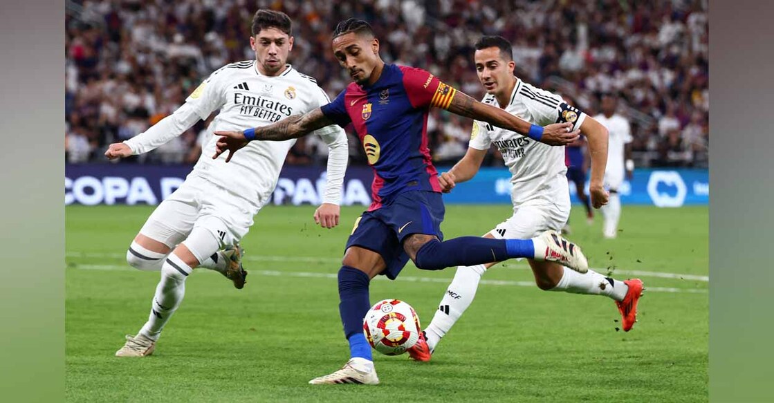 FC Barcelona's Raphinha in action with Real Madrid's Federico Valverde and Lucas Vazquez Photo: REUTERS/Pedro Nunes.