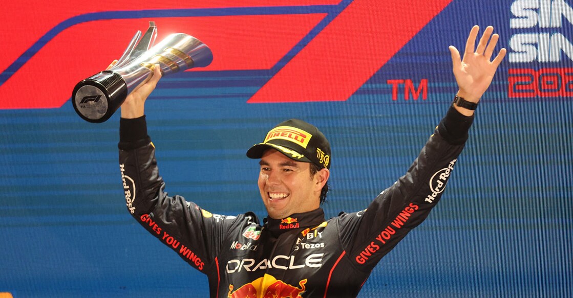 Red Bull's Sergio Perez celebrates with the trophy on the podium after winning the Singapore Grand Prix. Photo: Reuters/ Edgar Su