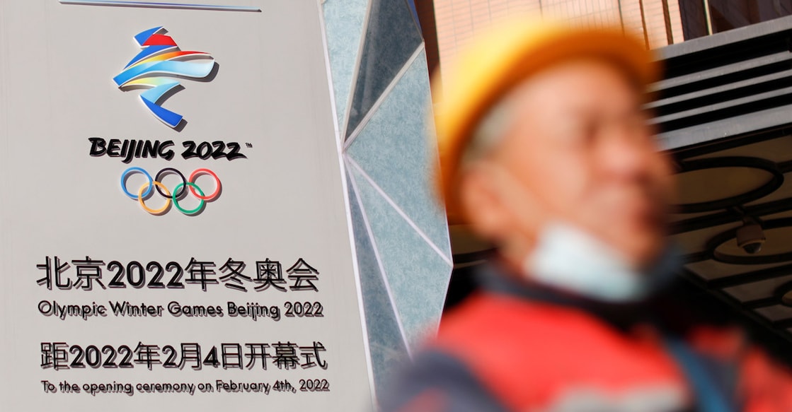 A man walks past a base relief containing the Olympic Rings as the city prepares for the Beijing 2022 Olympic Games. Photo: Reuters/Thomas Peter