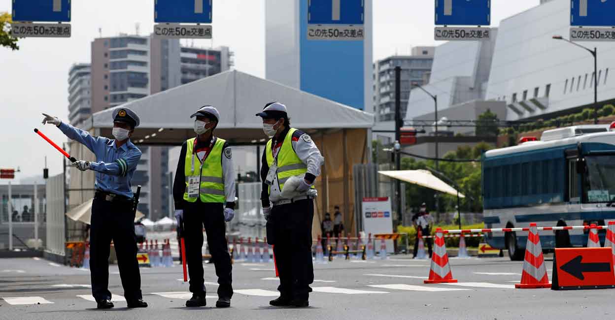 Police officers and security personnel stand guard at the entrance of the Athletes Village in Tokyo. Photo: Reuters