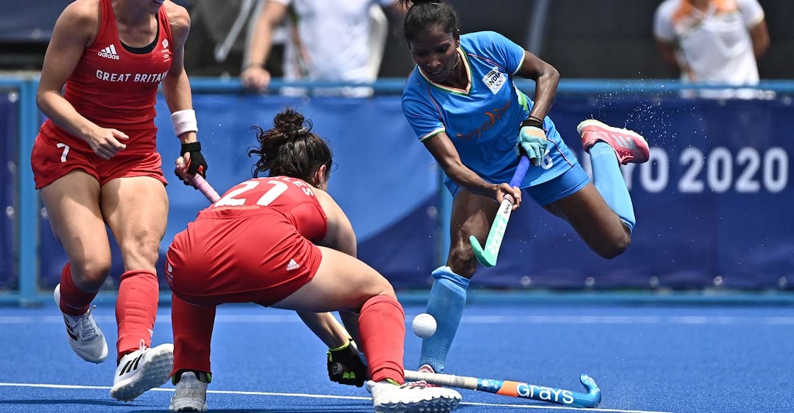 India's Nikki Pradhan (R) is blocked by Britain's Fiona Anne Crackles (C) during their women's pool A match.