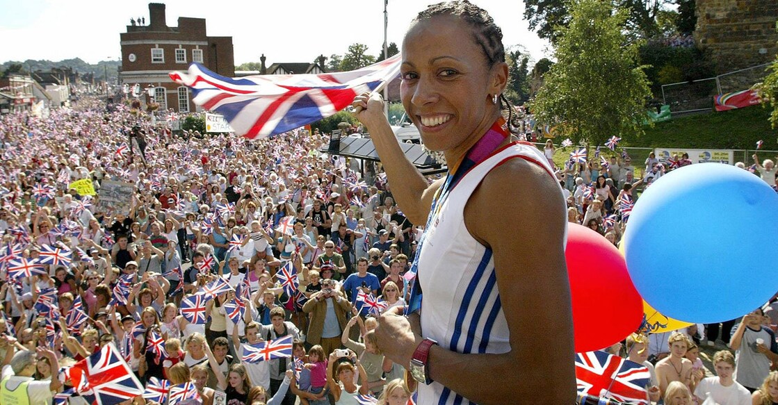 Kelly Holmes waves the Union Jack riding on a double decker bus as crowds line up the streets of her hometown Tonbridge during a victory parade  on September 1. 2004. File photo: AFP/Gareth Fuller