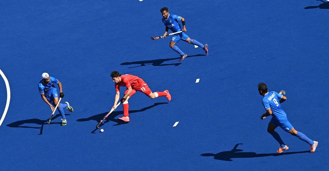 England's Philip Roper (C) runs with the ball during the Pool B hockey match between England and India on day four of the Commonwealth Games on August 1, 2022. PHOTO: AFP