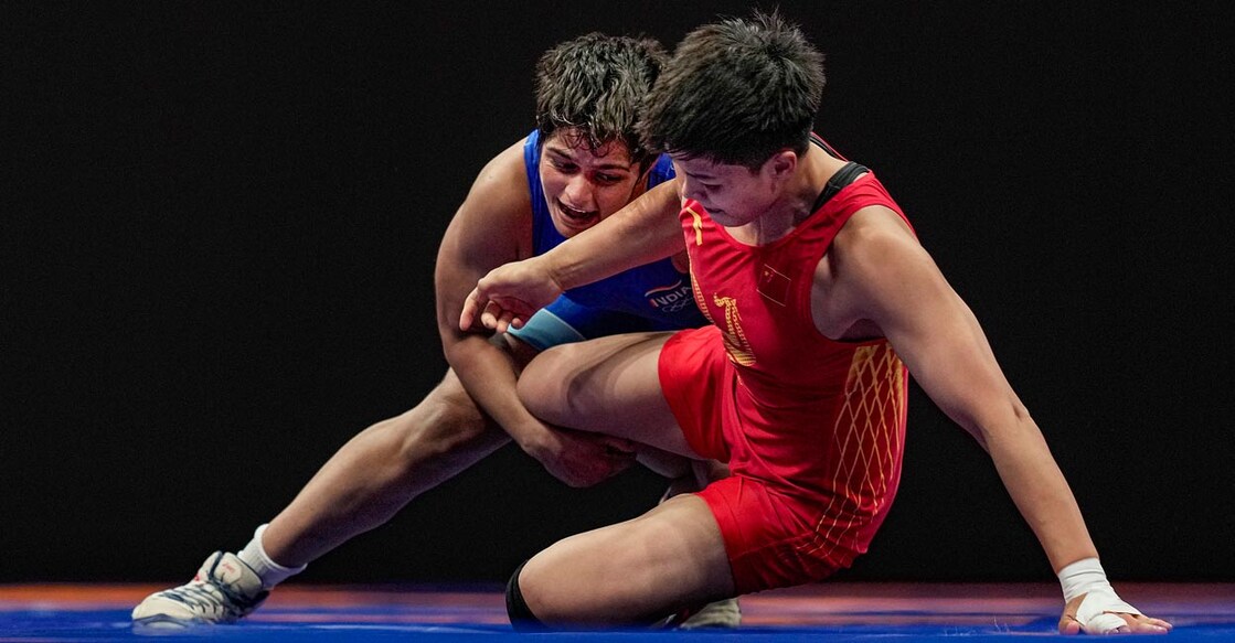 Sonam Malik, left, fights Jia Long in bronze medal playoff. Photo: PTI /Gurinder Osan