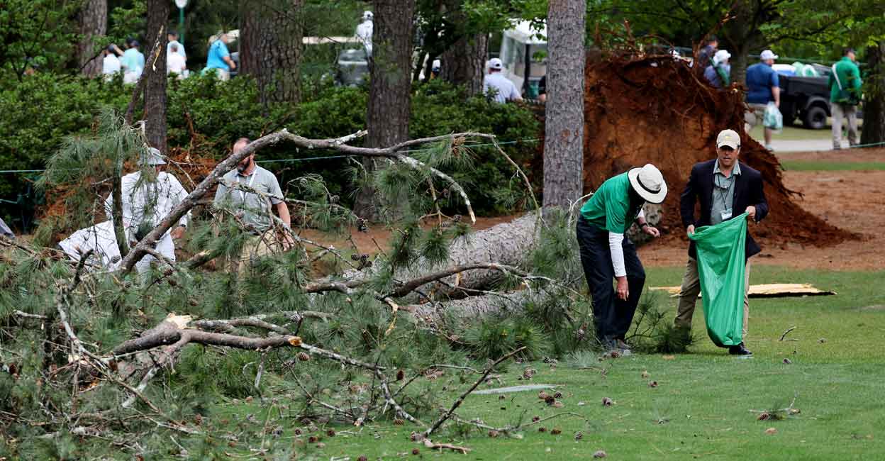 Pine trees fall near Augusta Masters patrons Ground staff collect debris on the fairway on the 17th hole. Photo: Reuters/Mike Blake