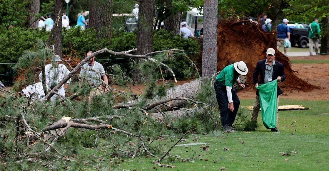 Ground staff collect debris on the fairway on the 17th hole. Photo: Reuters/Mike Blake