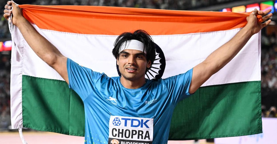 neeraj-javelin-c India's Neeraj Chopra celebrates with his National flag after the men's javelin throw final during the World Athletics Championships at the National Athletics Centre in Budapest on August 27, 2023. Photo: Kirill Kudryavtsev/ AFP)