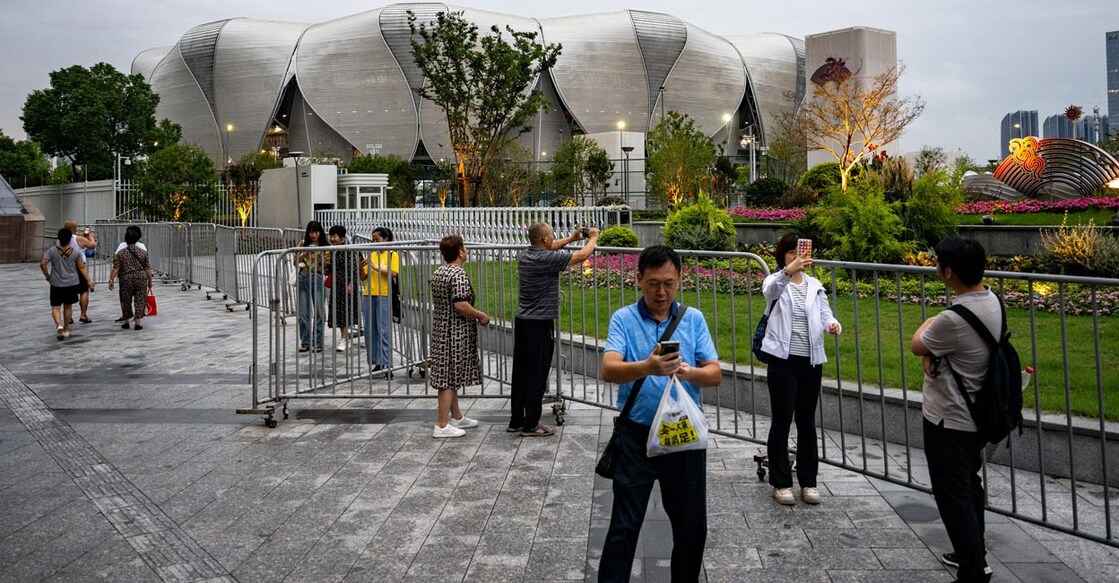People clik photos in front of the Hangzhou Olympic Sports Centre Stadium. Photo: AFP/Philip Fong 