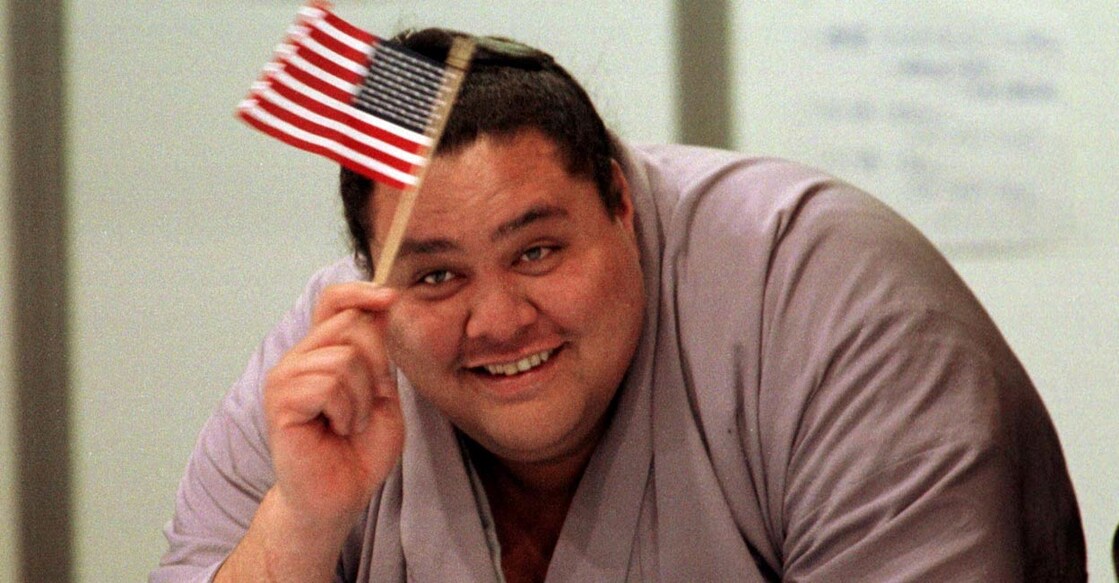 Akebono waves an American flag as he watches US skaters at the 1998 Winter Olympics. File Photo: Reuters