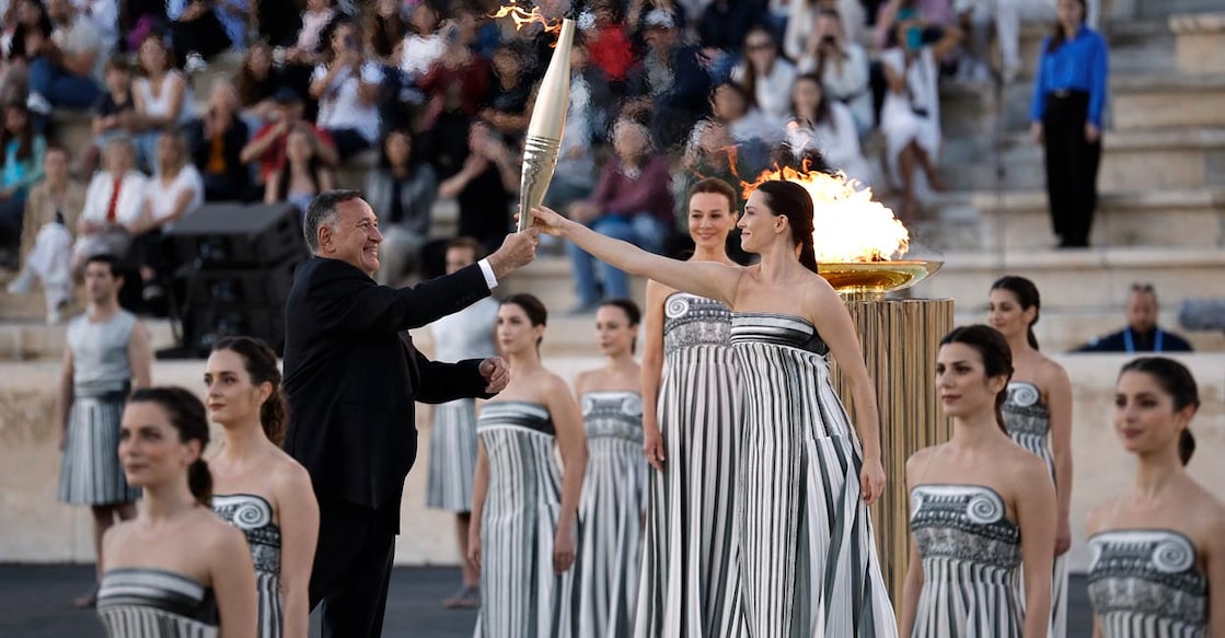 Olympics organisers receive flame in Athens Greek actress Mary Mina, playing the role of High Priestess, gives the torch to President of the Hellenic Olympic Committee and member of the International Olympic Committee Spyros Capralos. Photo: Reuters/Louiza Vradi