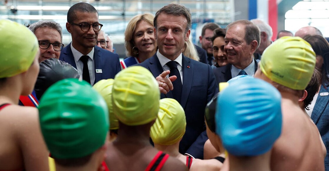 French president Emmanuel Macron talks to children after their swimming performance during the inauguration of the Olympic Aquatics Centre in Saint-Denis near Paris on Thursday. Photo: Reuters/Gonzalo Fuentes