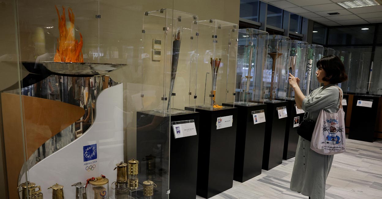 A visitor looks at the exhibits from the collection of Stratos Klimou during a temporary exhibition of historic Olympic torches in Ancient Olympia, Greece, on April 16, 2024. File photo:  Reuters/Louisa Gouliamaki