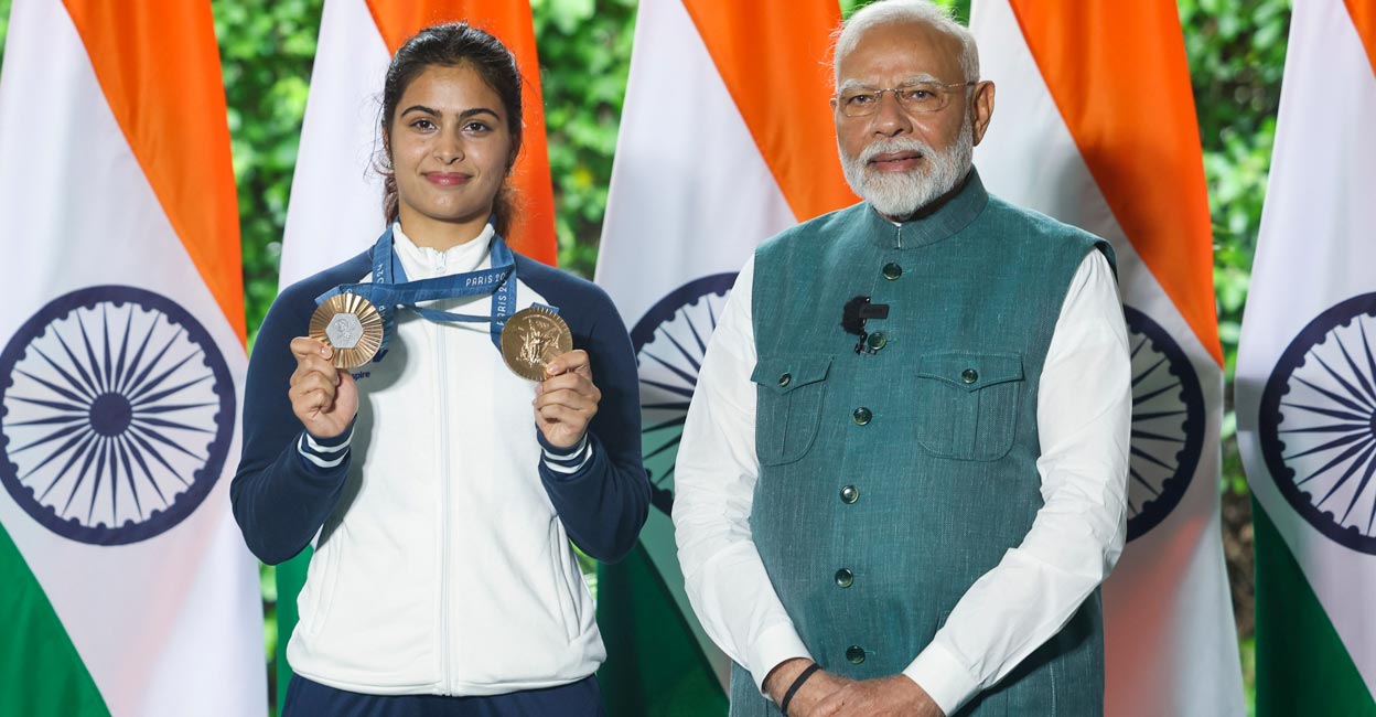 Manu Bhaker & PM Modi Manu Bhaker displays her medals during the interaction with Narendra Modi. Photo: PTI