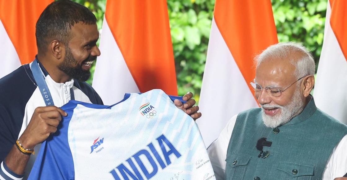 Sreejesh presents a jersey signed by the national team players to PM Modi. File photo: IANS