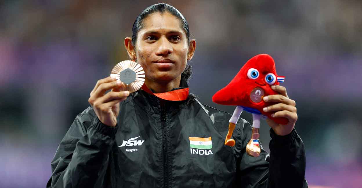 Deepthi Jeevanji of India celebrates on the podium. Photo: Reuters/Thomas Mukoya