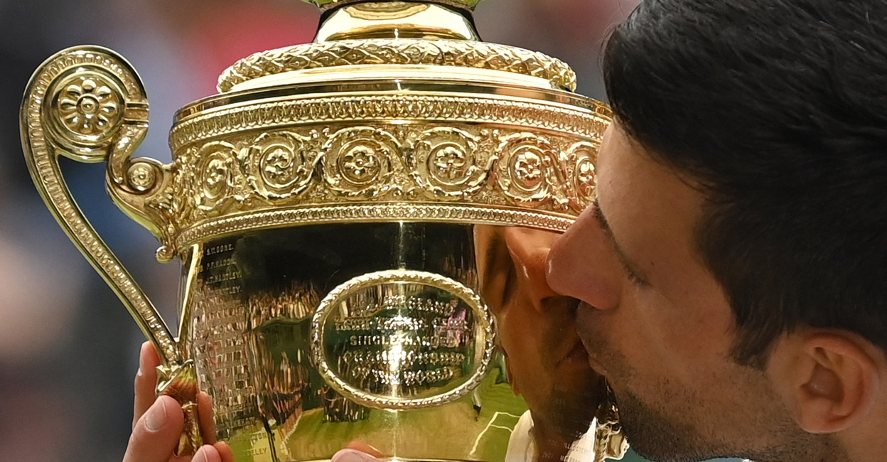 Novak Djokovic kisses the winner's trophy after cilnching the Wimbledon last year. File photo: AFP/Glyn Kirk