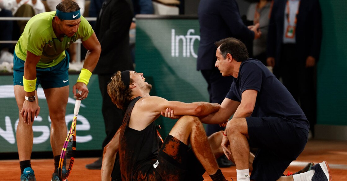 Alexander Zverev receives medical attention after sustaining an injury as Spain's Rafael Nadal looks on. Photo: Reuters/Yves Herman