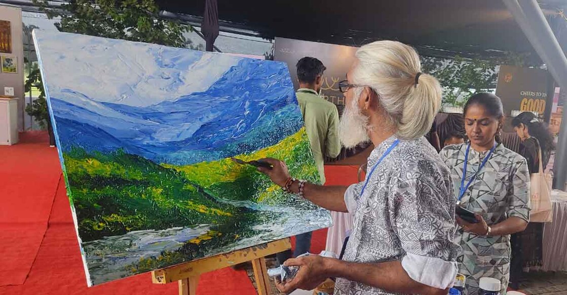 Artist Gireeshan Bhattathirippad of Punnayoorkulam paints at the venue of Splash 2023, Wayanad's annual monsoon carnival. Photo: Wayanad Tourism Organisation