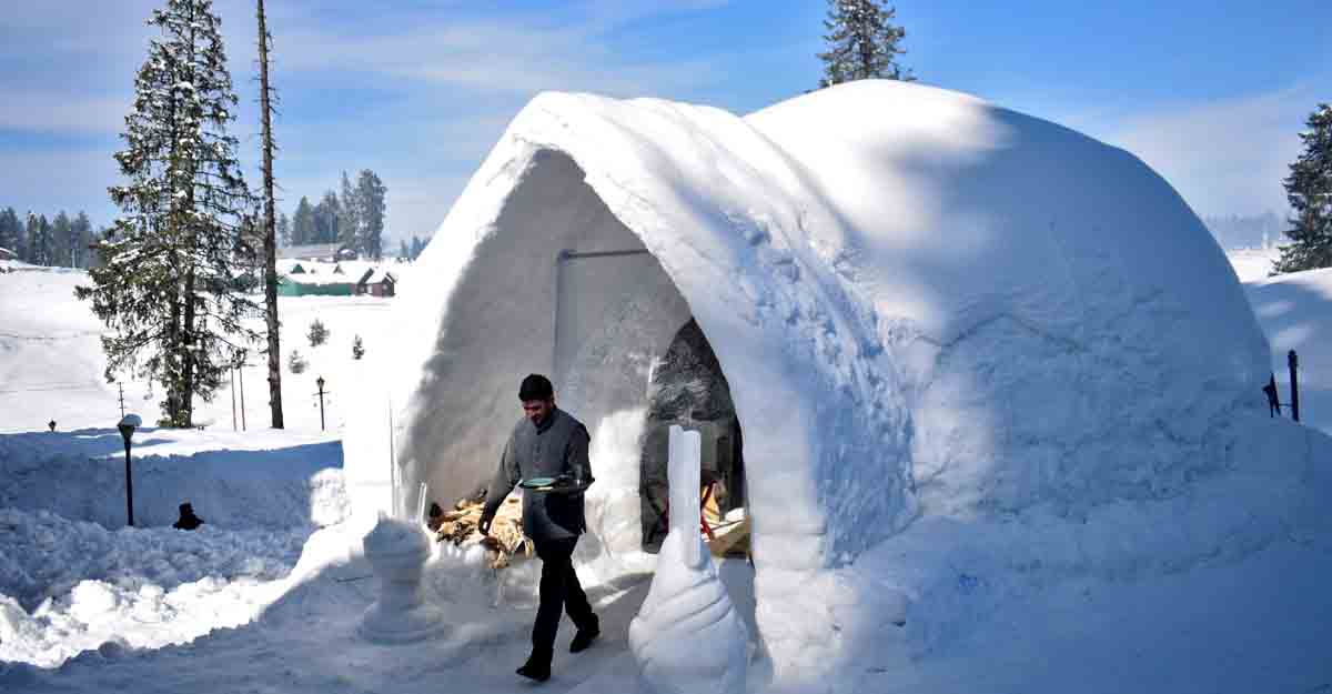 A waiter comes out of "Igloo Cafe", a cafe prepared with snow and ice, after serving customers at Gulmarg, a ski resort and one of the main tourist attractions in Kashmir region, January 28, 2021. REUTERS/Sanna Irshad Mattoo/Files