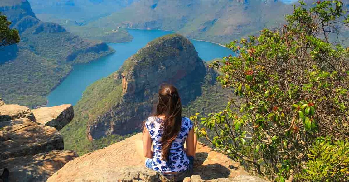 Girl sitting on stone on the cliff in the Blyde River Canyon, South Africa