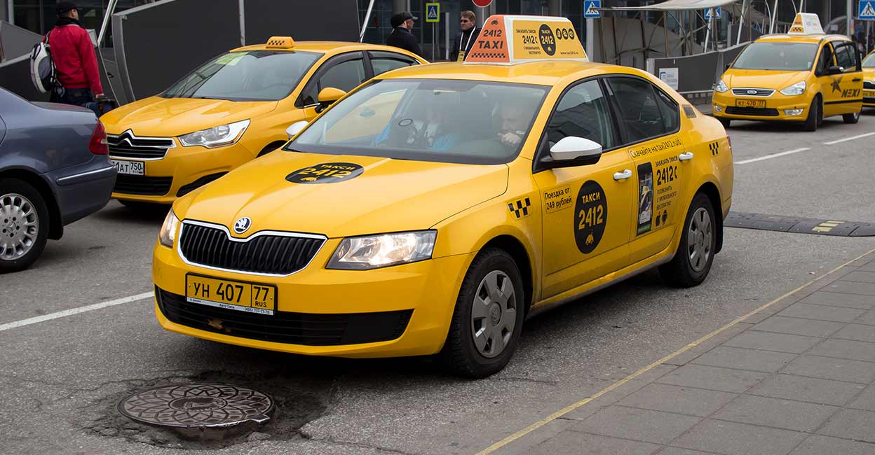 russia-airport-taxi Yellow taxi stand at the entrance of the airport Sheremetyevo. Photo: iStock/tanyss