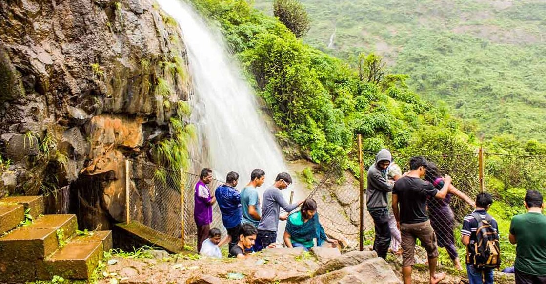 Tourists enjoy a waterfall at Lonavala. Photo: iStock/naveen0301