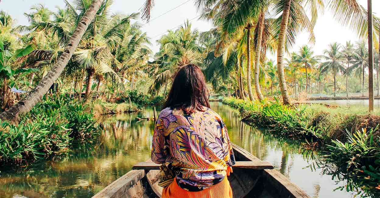 A young woman kayaks through the backwaters of Munroe Island in Kollam District, Kerala, South India. Photo: iStock/SolStock