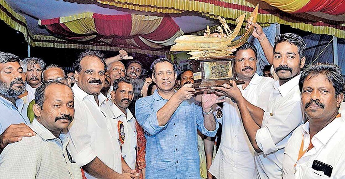 Justice Bechu Kurian Thomas handing over the  K C Mammen Mappillai Trophy to Ranju Abraham Kallupurackkal , who captained the snake-boat Gabriel Chundan at the 64th Uthradam Thirunal Pampa Water Festival held at Neerettupuram Pampa Water Stadium. Photo: Manorama