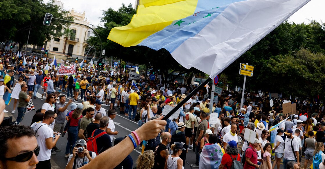 A man waves a flag with the colours of the Canary Islands during a demonstration for a change in the tourism model in the Canary Islands, in Santa Cruz de Tenerife, Spain. Photo: Reuters/Borja Suarez