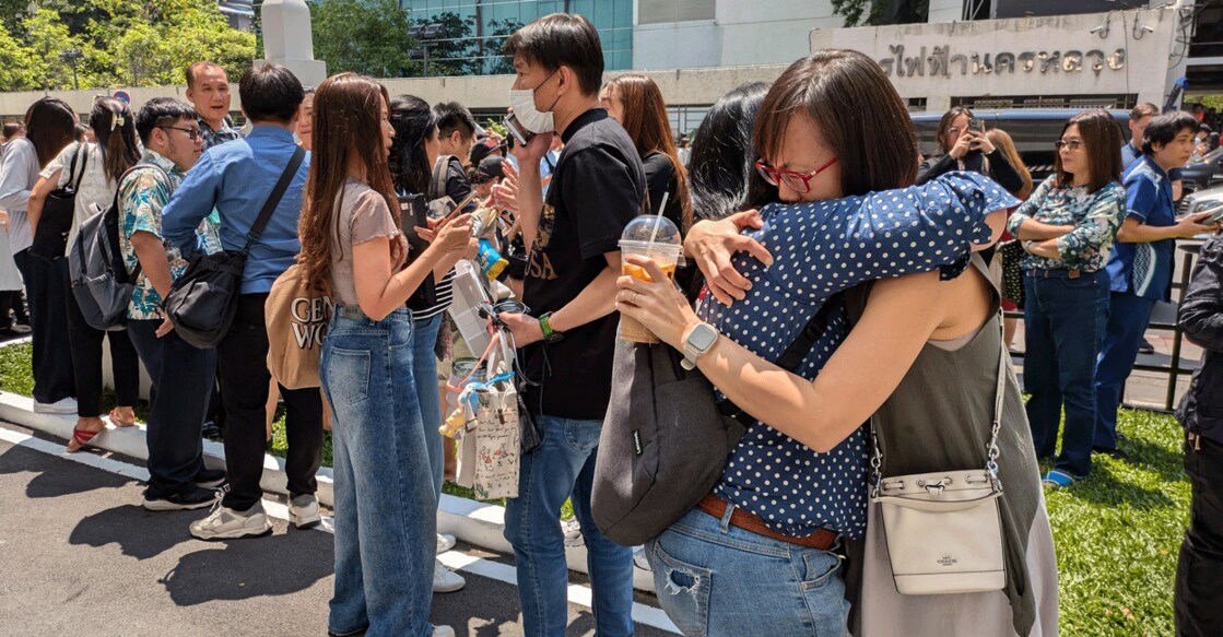 People stand outside a building in Bangkok on March 28, 2025 after an earthquake. Photo: AFP