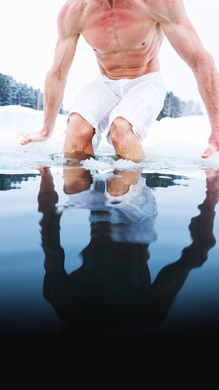 Divers cut a hole in the ice to enter the cold, clear water. 