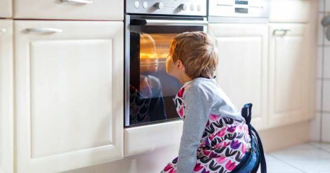 Little kid using baking oven