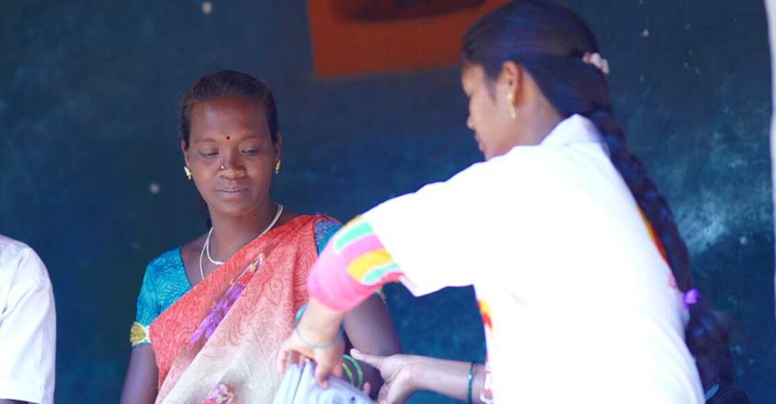 A midwife conducting basic tests on a pregnant woman.