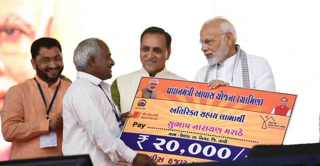 Prime Minister Narendra Modi felicitates beneficiaries of various development schemes during a public meeting in Valsad, Gujarat on Aug 23, 2018 | Photo: IANS